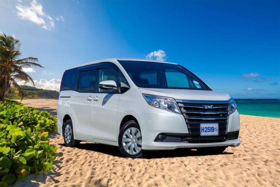 White Toyota Noah van on a sunny Caribbean beach